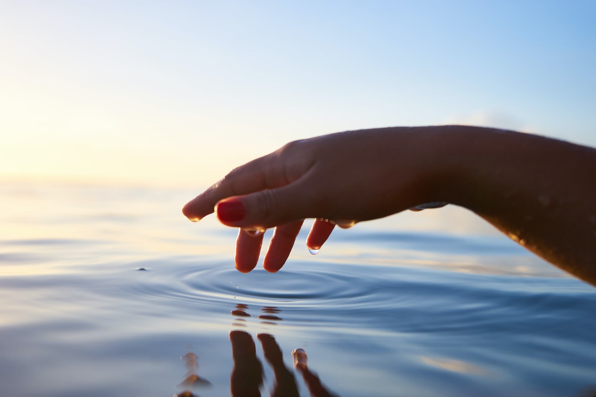 woman's hand touching water